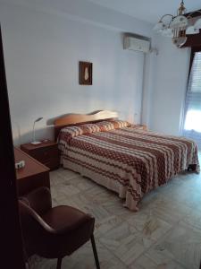 - une chambre avec un lit, un bureau et une chaise dans l'établissement Appartamento Elisa, à Melito di Porto Salvo