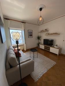 uma sala de estar com um sofá e uma televisão em Appartamento Victoria em Camogli