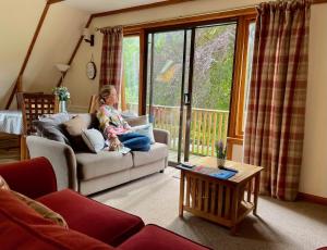 a little girl sitting on a couch in a living room at Ericht Holiday Lodges in Blairgowrie