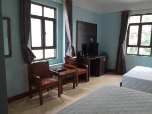 a hotel room with a bed and a desk and chairs at Hien Thuc Hotel in Ninh Binh