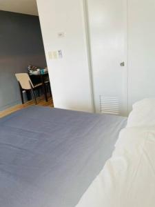 um quarto com uma cama branca e uma mesa com uma cadeira em Studio Type Condo with WiFi em Biñan