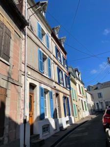 szereg domów z niebieskimi drzwiami na ulicy w obiekcie Charmante maison de pêcheur à Trouville sur Mer w mieście Trouville-sur-Mer +9 zdjęć