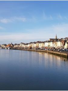 duży zbiornik wody z miastem w tle w obiekcie Charmante maison de pêcheur à Trouville sur Mer w mieście Trouville-sur-Mer