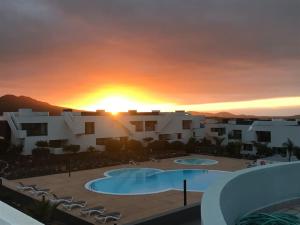 puesta de sol sobre un complejo con 2 piscinas en Suite Dreams Fuerteventura, en Villaverde