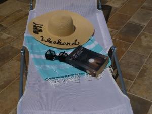 - une chaise de plage avec un chapeau, une bouteille et des verres dans l'établissement Don Turiddu, à Donnalucata