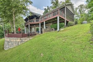 a large house on top of a grassy hill at Waterfront Getaway with Fire Pit and Game Room! in Iva