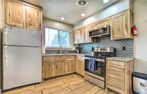 a kitchen with wooden cabinets and a white refrigerator at Cozy Townhome Near Dtwn, Hospital and College! in Pocatello