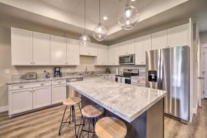 Swan ValleyにあるModern Swan Valley Townhome with Walking Trailsの白いキャビネットとスツール付きの大きな島のあるキッチンが備わります。