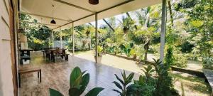un gran salón acristalado con vistas al jardín en Baan Hinlad Home and Hostel, en Lipa Noi