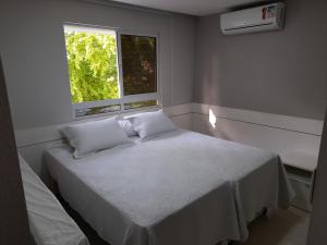 a bedroom with a white bed and a window at Beira Mar Premium Apart - Solar do Atlântico Tambaú in João Pessoa +31 photos