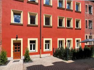 een rood gebouw met een bruine deur en ramen bij Nurban Apartments City Nürnberg in Neurenberg