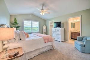 um quarto com uma cama e uma cadeira e uma ventoinha de tecto em Bright Florida Home Near Tons of Golf Courses em The Villages