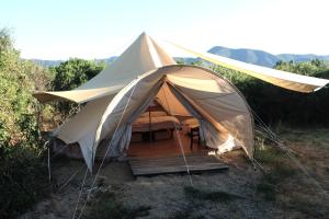 a tent with a table and chairs in a field at ecoVita agri-glamping in San Vito