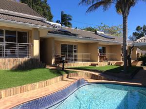 a house with a swimming pool in front of a house at TeBeacon Accommodation in East London
