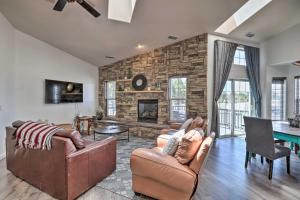 sala de estar con muebles de cuero y pared de piedra. en Modern Flagstaff Home Deck, Patio and Fire Pit, en Mountainaire