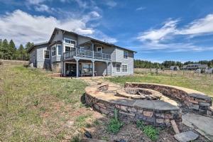 Una casa grande con una fogata en un campo. en Modern Flagstaff Home Deck, Patio and Fire Pit, en Mountainaire