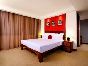 a bedroom with a large bed with a red wall at Butterfly on Wellington, Central in Hong Kong