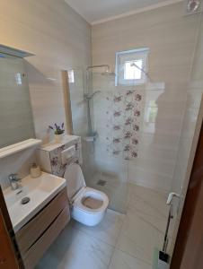 een badkamer met een douche, een toilet en een wastafel bij Apartments Magnolija 50m from beach in Srima