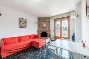 ein Wohnzimmer mit einem roten Sofa und einem Tisch in der Unterkunft Casa Taphouse in Malcesine