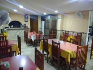 a restaurant with tables and chairs with yellow table cloth at Hotel Colonial Inn in Barranquilla
