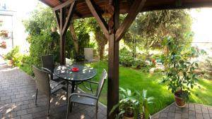 a patio with a table and chairs under a gazebo at Apartament Bronowice in Krakow +1 photo