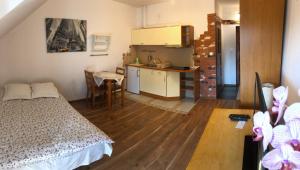 a bedroom with a bed and a kitchen with a table at Apartament Bronowice in Krakow