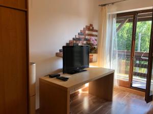 a television on a desk in a room with a window at Apartament Bronowice in Krakow