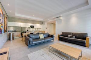 a living room with two leather couches and a table at Le Kube - Appartements de Prestige au centre d'Annecy in Annecy