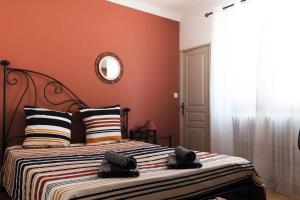 1 dormitorio con 1 cama con paredes de color naranja y espejo en Le Mas d'Argens - Maison avec Jardin et Jacuzzi - Accès rivière, en Lorgues