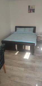 a bed sitting in a bedroom with a wooden floor at Garsoniera Turda Maria in Turda