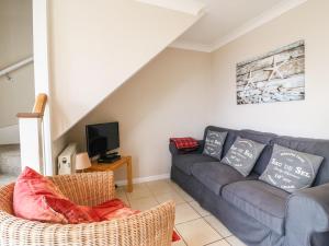 sala de estar con sofá y TV en Sea Breeze en Weymouth