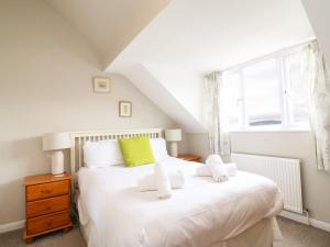 a bedroom with a white bed and a window at Sea Breeze in Weymouth