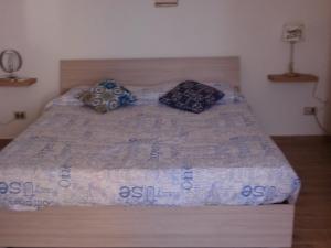 DMZ - Agrigento Apartment في أغريغينتو: سرير مع وسادتين جالسين عليه