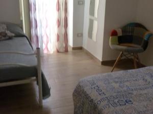 DMZ - Agrigento Apartment في أغريغينتو: غرفة نوم بسرير وكرسي