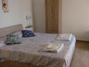 DMZ - Agrigento Apartment في أغريغينتو: غرفة نوم عليها سرير وفوط