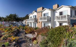 a row of houses on a hill with flowers at Pelican Inn & Suites in Cambria