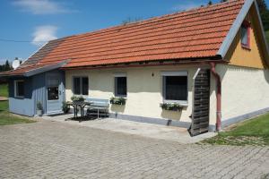 阿爾戈伊地區洛伊特基希的住宿－Ferienwohnung Kleiner Spatz，白色的建筑,有橙色的屋顶和桌子