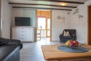 a living room with a table with a bowl of fruit at Ferienwohnung Kleiner Spatz in Leutkirch im Allgäu