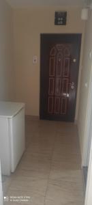 a black door in a room with a tile floor at Garsoniera Turda Maria in Turda