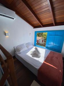 a bedroom with a bed and a window at Espaço Tropicália in Pirenópolis