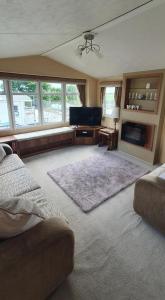 sala de estar con sofá y TV de pantalla plana en A-Wave From It All en Montrose