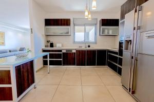 a kitchen with wooden cabinets and a blue counter top at Luxury Marina 4BR apartment by Airsuite in Ashdod