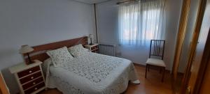 a bedroom with a bed and a chair and a window at Apartamento Sopuente in Selaya