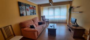 a living room with a couch and a tv at Apartamento Sopuente in Selaya
