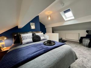 a bedroom with a large bed with a blue wall at Boutique 5 bed home on Birdwell Road - Free parking in Attercliffe
