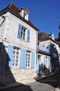 een oud wit gebouw met blauwe luiken op een straat bij B&B Le Relais des Saints Pères in Auxerre