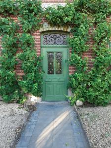 een groene deur aan de zijkant van een bakstenen gebouw bij Villa Ritte in Dendermonde