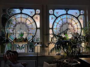 three stained glass windows in a room with a plant at Villa Ritte in Dendermonde