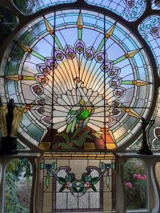 ein Buntglasfenster mit Papagei drauf. in der Unterkunft Villa Ritte in Dendermonde