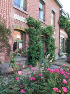 ein Backsteingebäude mit rosa Blumen davor in der Unterkunft Villa Ritte in Dendermonde